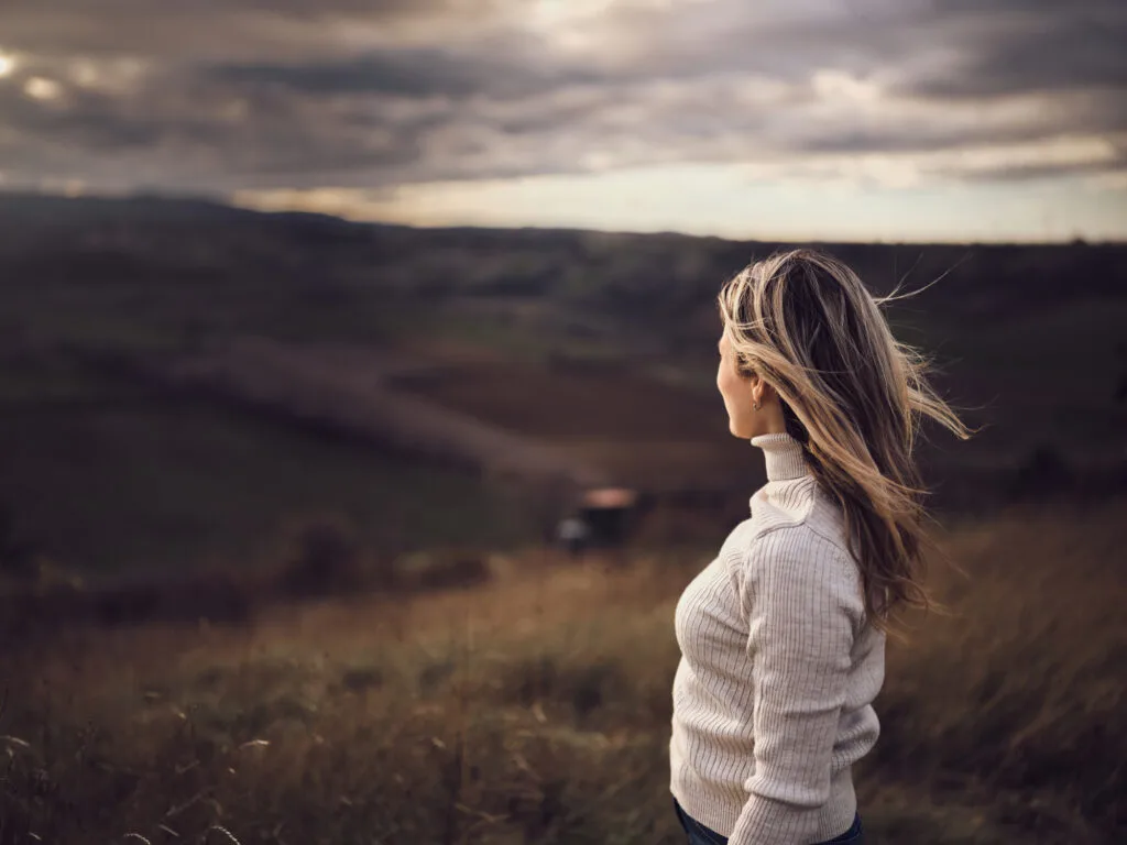 Carefree woman looking at autumn view from a hill.